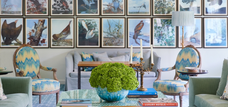 Coffee table and multicolored accent furniture in front of the Treehouse gallery wall